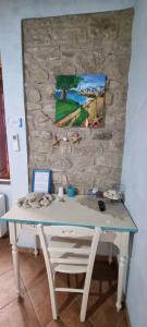 a desk in a room with a stone wall at B&B Martina in Senorbì