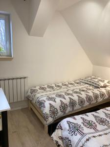 dwa łóżka pojedyncze w pokoju z oknem w obiekcie Apartament BB I na Kiepury w mieście Krynica Zdrój