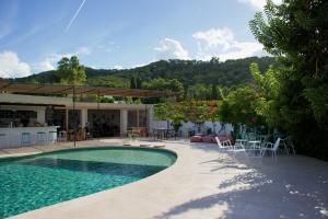 a swimming pool with chairs and tables and a house at La Pandilla Ibiza in Sant Francesc de s'Estany