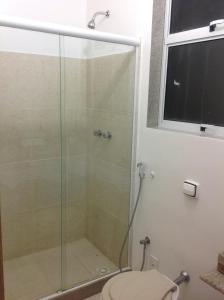 uma casa de banho com uma cabina de duche em vidro e um WC. em Apartment Copacabana Beach no Rio de Janeiro