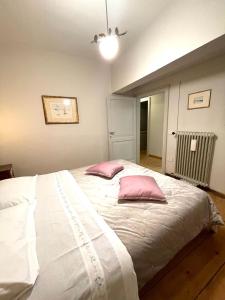 um quarto com uma grande cama branca e 2 almofadas cor-de-rosa em Villa Vitturi em Maserada sul Piave