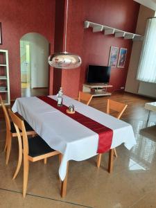 a dining room table with a white and red table cloth at Ferienwohnung Rosengarten in Öhringen