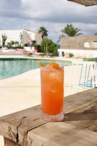 a drink sitting on a table next to a pool at La Pandilla Ibiza in Sant Francesc de s'Estany