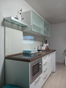 a small kitchen with white cabinets and a sink at Antonina apartment in Skopje