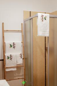 een badkamer met handdoeken op een handdoekenrek naast een spiegel bij Apuja - Apulian Experience in Bari