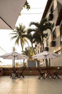 zwei Stühle und Sonnenschirme vor einem Gebäude in der Unterkunft Hotel Plage in Rio de Janeiro