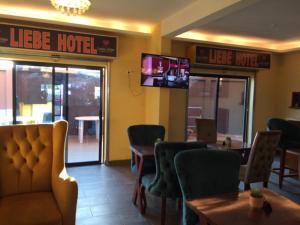 un restaurant avec des tables et des chaises et une enseigne indiquant « hôtel de vie » dans l'établissement LIEBE HOTEL, à Yaoundé