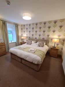 a bedroom with a large bed with two lamps on it at Royal Oak Braithwaite in Keswick