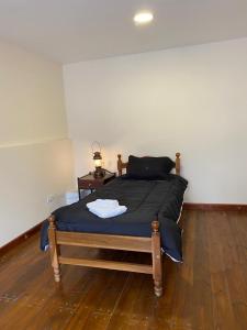 a large bed in a room with a wooden floor at Casa Los Perales in San Salvador de Jujuy