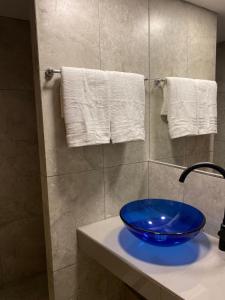 a bathroom with a blue bowl on a sink at Casa Los Perales in San Salvador de Jujuy