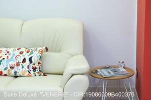 een witte stoel met een kussen en een tafel bij ROCCA DI CERERE Self Check-in Apartments in Enna