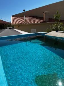 a large blue swimming pool in front of a house at Casa do Eirô in Resende