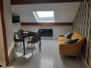 een woonkamer met een tafel en een bank bij Appartement du parc in Xonrupt-Longemer