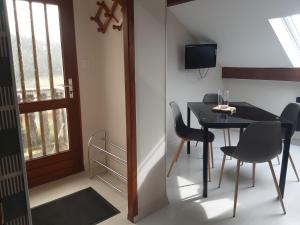 een eetkamer met een tafel en stoelen en een televisie bij Appartement du parc in Xonrupt-Longemer
