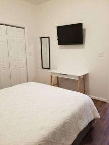 a bedroom with a bed and a desk and a television at Tiny home rentals near Ft Moore in Phenix City
