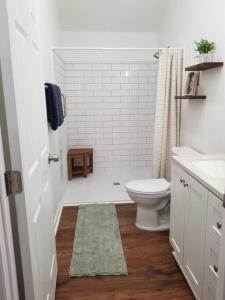 a white bathroom with a toilet and a sink at Tiny home rentals near Ft Moore in Phenix City
