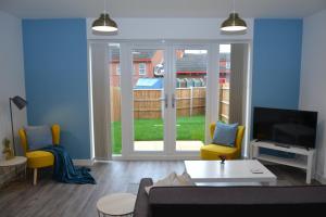 uma sala de estar com um sofá e uma grande janela em Erasmus House - 3 Bedrooms - City Centre, Netflix, WIFI, Free Private Parking em Derby