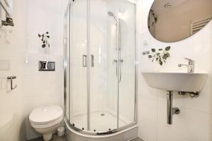 een badkamer met een douche, een toilet en een wastafel bij Willa Portus in Słupsk