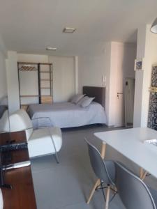 1 dormitorio con 1 cama, mesa y sillas en Sortie en Rosario