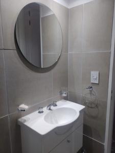 y baño con lavabo blanco y espejo. en Sortie en Rosario