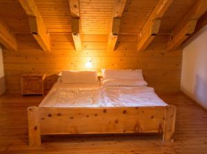 Cama de madera en habitación con techo de madera en Chalet Sennhütte Obertauern mit Zirbensauna und neuem XL Bad, en Obertauern