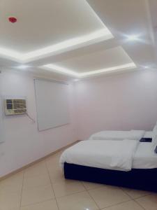 um quarto com uma cama num quarto branco em قصر اباهي للوحدات السكنية em Al Jubail