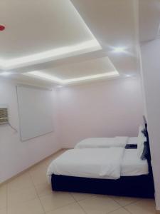 a bedroom with a bed in a white room at قصر اباهي للوحدات السكنية in Al Jubail