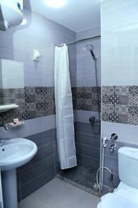 a bathroom with a shower and a toilet and a sink at Lamera Hotel in Hurghada