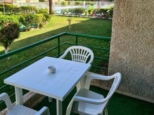 uma mesa branca e cadeiras numa varanda em Viñas by Villas Rinamar em Playa de las Americas
