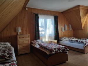 ザコパネにあるPokoje Gościnne Janinaのベッドルーム1室(ベッド2台、ドレッサー、窓付)