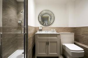 a bathroom with a toilet and a sink and a mirror at The Christopher Hotel, Eton in Windsor