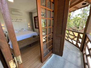 Habitación con vistas a un dormitorio con cama y balcón. en Studios Aromas do Campeche - Floripa, en Florianópolis