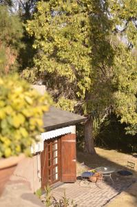 un pequeño cobertizo de madera con mesa y sillas en Alto Chacras Cottage en Chacras de Coria