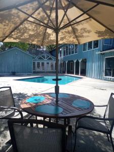 una mesa de patio con sombrilla frente a la piscina en 10 beds 5 baths 24 acre Lake Property minutes The Woodlands TX, en Magnolia