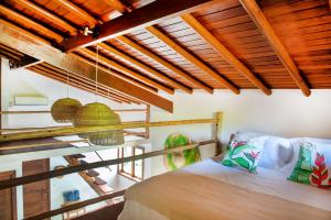 1 dormitorio con 1 cama en una habitación con techos de madera en Casa Tetéia, en Arraial d'Ajuda