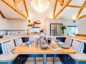 a large kitchen with a wooden table and chairs at The Farmhouse - within the Helland Barton Farm collection in Delabole