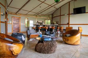 a living room with wooden furniture and a table and chairs at Moon Wonders Vacation House in Monteverde Costa Rica