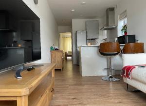 a room with a kitchen and a living room at Newly built modern flat at London Gants Hill Station near Ilford in Wanstead