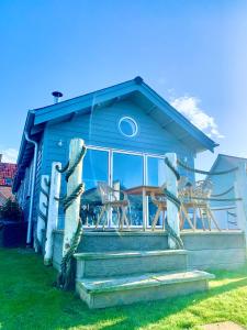 a blue house with a staircase and chairs on it at Jubilee Beach House in Filey
