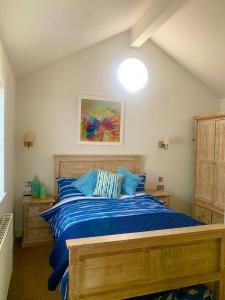 a bedroom with a wooden bed with blue sheets at Jubilee Beach House in Filey