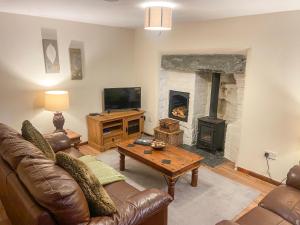 a living room with a couch and a fireplace at Weaver's Cottage in Porthmadog