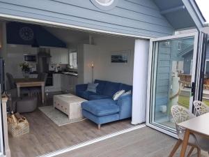 a living room with a blue couch on a patio at Jubilee Beach House in Filey