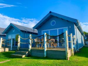 a blue house with a porch and a deck at Jubilee Beach House in Filey