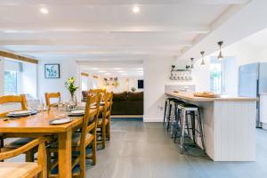 una cucina e una sala da pranzo con tavolo e sedie in legno di The Old Bakehouse - within the Helland Barton Farm collection a Delabole