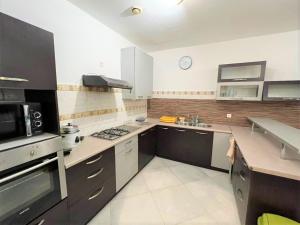 a large kitchen with a stove and a microwave at Appartements - Le Paradisier Ambatobe in Antananarivo +45 photos