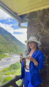 una mujer con un vestido azul y sombrero sosteniendo un plato en Aldea Real Eco Friendly, en Baños