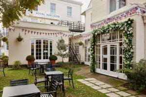 a patio with tables and chairs in front of a building at The Royal Adelaide Hotel in Windsor