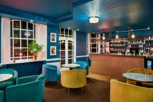 un restaurante con mesas y sillas y un bar en The Royal Adelaide Hotel en Windsor