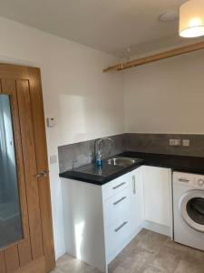 a kitchen with a sink and a washing machine at Wasterview, Central Mainland, Ideal base in Lerwick