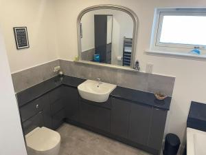 een badkamer met een wastafel, een toilet en een spiegel bij Wasterview, Central Mainland, Ideal base in Lerwick